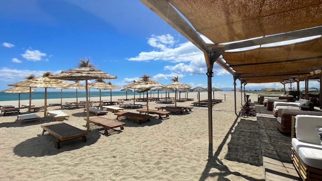 Vue panoramique de la plage privée et des transats face à la mer