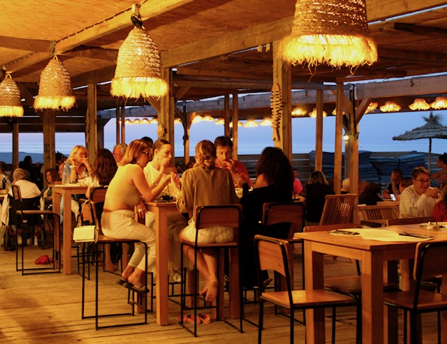 Convives au bar en soirée, ambiance dorée